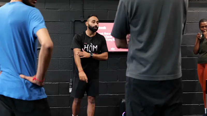 A Hōm coach briefing a small group before training